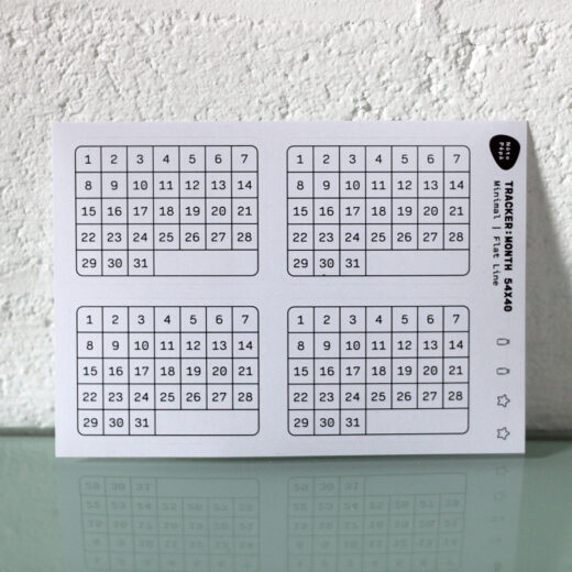 Product Photography Monthly Habit Tracker Sticker Sheet on desk with brick wall as background