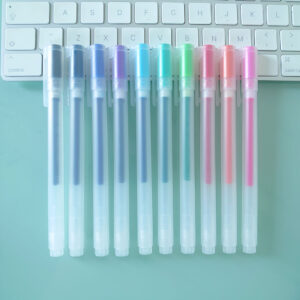 Noto Pepa Product photography MUJI Gel Ink Ballpoint Cap Type Pen - Set of 10 (0.38mm) Colours on desk and keyboard, view from the side of the pens